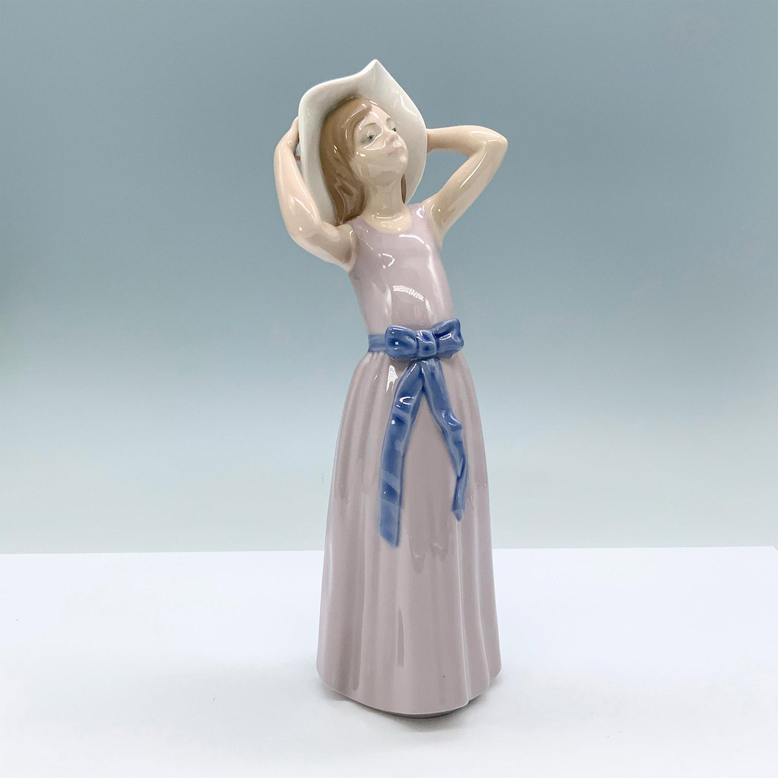 Coy 1005011 - Lladro Porcelain Figurine: Glossy finish; Lladro backstamp. Artist: Francisco Catala Issued: 1978 - 1998 Dimensions: 10.25"H x 4"W Manufacturer: Lladro Country of Origin: Spain