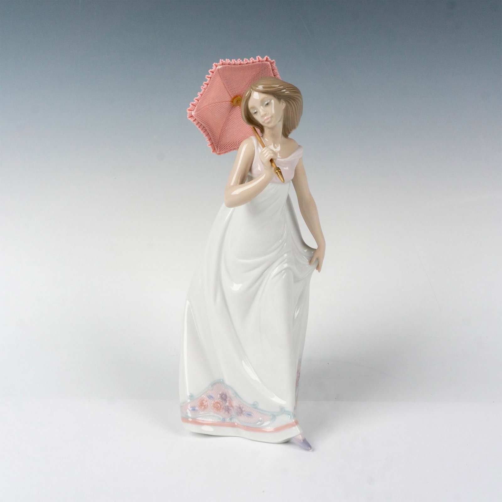 Afternoon Promenade 1007636 - Lladro Porcelain Figurine: Glossy finish; Lladro backstamp. Box measures: 7.5"L x 6"W x 12.75"H. Artist: Jose Puche Issued: 1995 - 1995 Dimensions: 11"H x 4.25"W Manufacturer: Lladro Country of Origin: Spain
