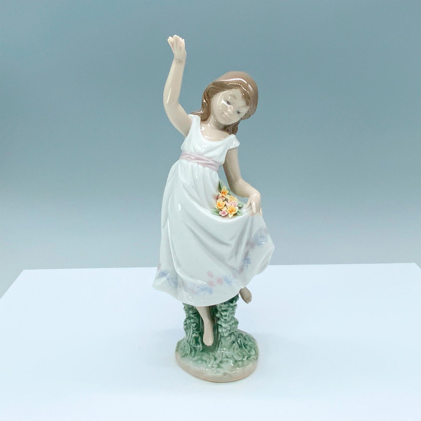 Garden Dance 1006580 - Lladro Porcelain Figurine: Glossy finish; Lladro backstamp. Box measures: 6.75"L x 5.5"W x 12"H. Artist: Jose Javier Malavia Issued: 1999 - 2000 Dimensions: 9"H x 4"W Manufacturer: Lladro Country of Origin: Spain