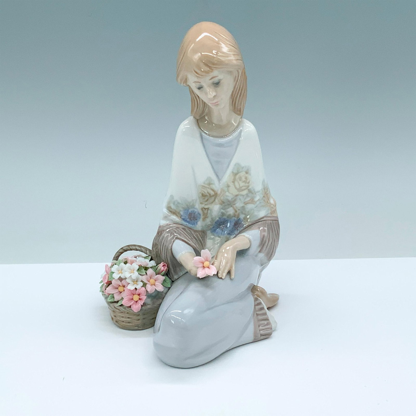 Flower Song 1007607 - Lladro Porcelain Figurine: Glossy finish; Lladro backstamp. Box measures: 9.25"L x 9.75"W x 6.5"H. Artist: Juan Huerta Issued: 1988 - 1989 Dimensions: 7.5"H x 5.5"W Manufacturer: Lladro Country of Origin: Spain