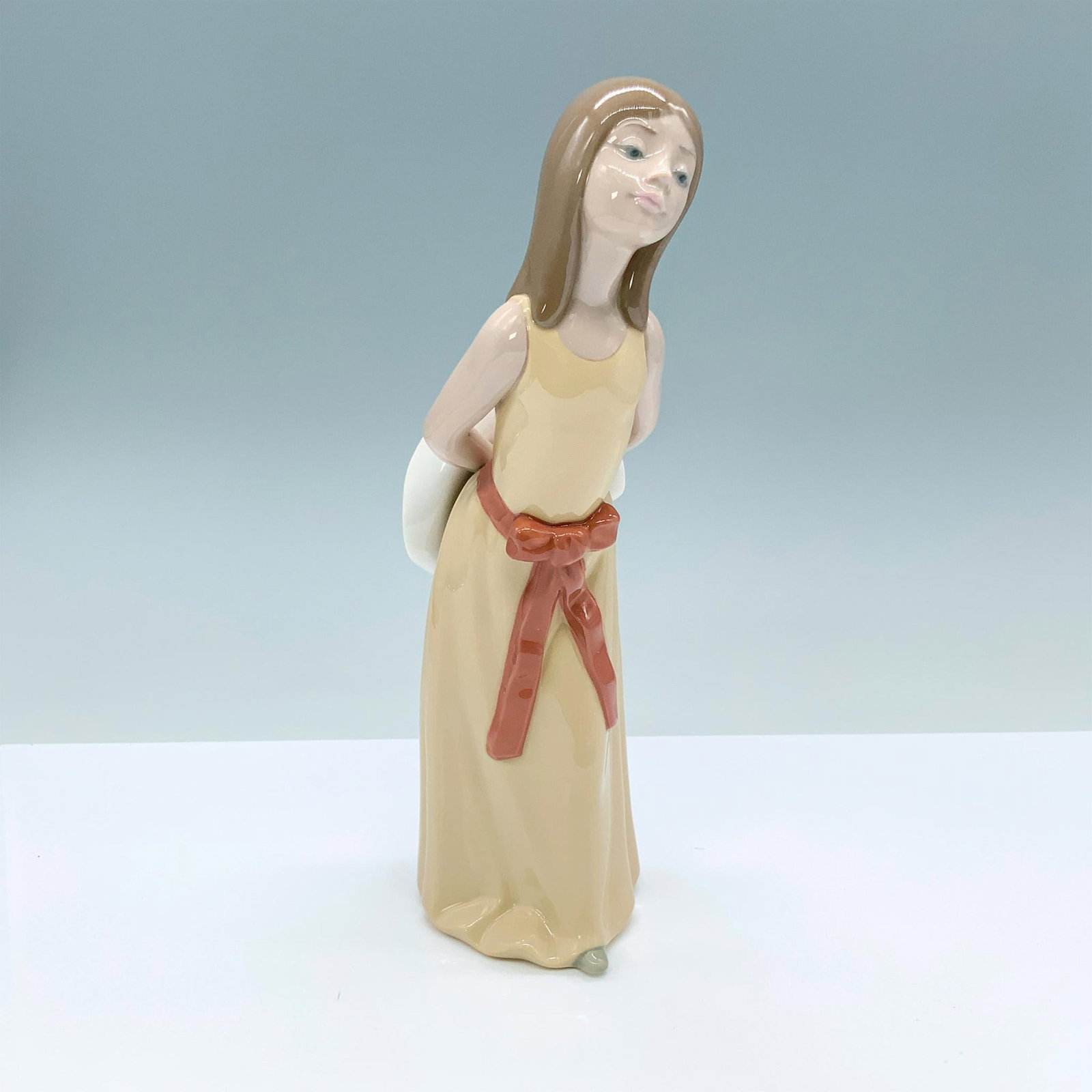 Naughty 1005006 - Lladro Porcelain Figurine: Glossy finish; Lladro backstamp. Artist: Francisco Catala Issued: 1978 - 1998 Dimensions: 9.75"H x 4"W Manufacturer: Lladro Country of Origin: Spain