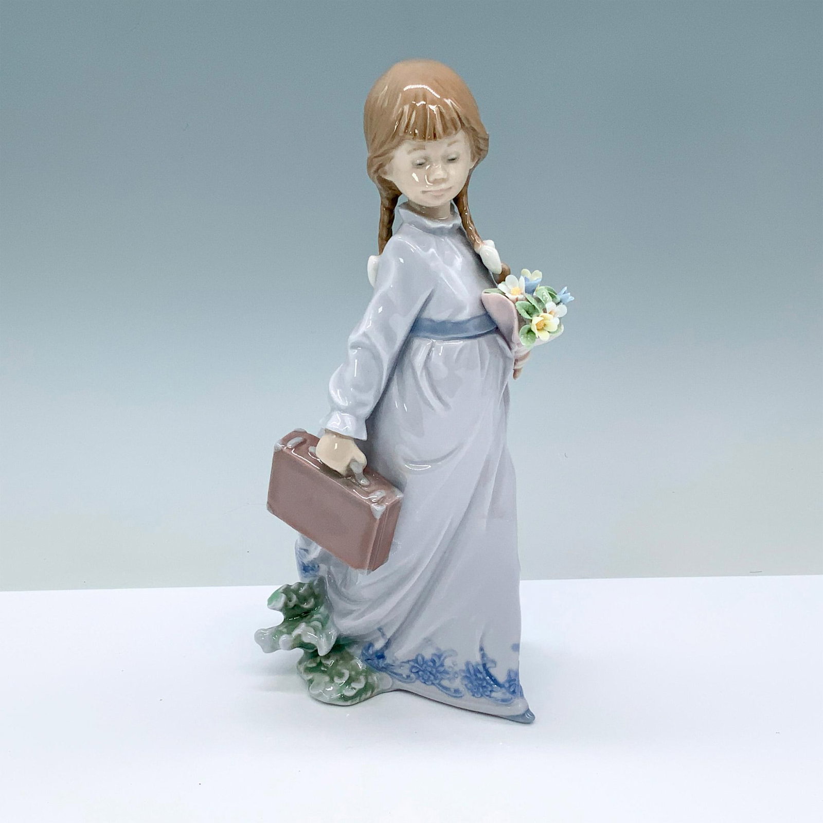 School Days 1007604 - Lladro Porcelain Figurine: Glossy finish; Lladro backstamp. Box measures: 7.5"L x 6.25"W x 12.5"H. Artist: Antonio Ramos Issued: 1988 - 1988 Dimensions: 8.25"H Manufacturer: Lladro Country of Origin: Spain