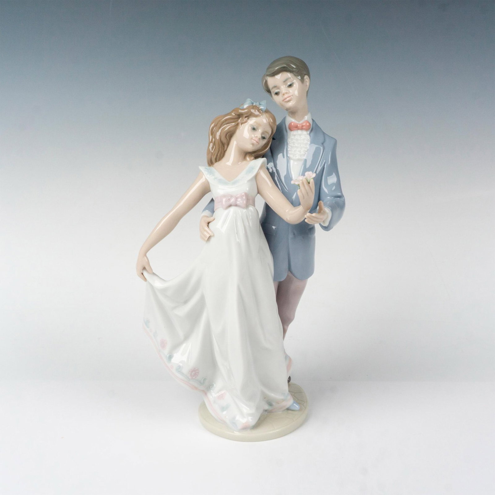 Now And Forever 1007642 - Lladro Porcelain Figurine: Glossy finish; Lladro backstamp. Box measures: 9.5"L x 8.5"W x 13.75"H. Artist: Francisco Polope Issued: 1995 - 1995 Dimensions: 10.75"H x 6"W Manufacturer: Lladro Country of Origin: Spain