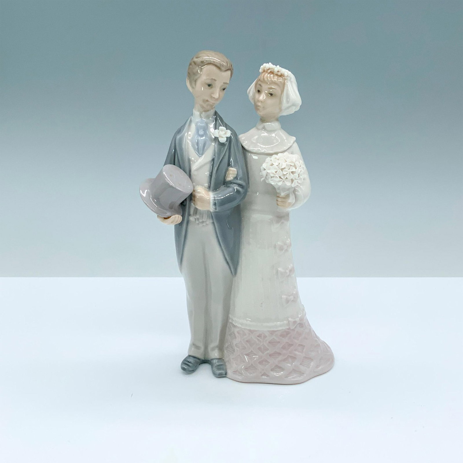 Wedding 1004808 - Lladro Porcelain Figurine: Glossy finish; Lladro backstamp. Artist: Julio Fernandez Issued: 1972 - 2004 Dimensions: 7.75"H x 3.5"W Manufacturer: Lladro Country of Origin: Spain