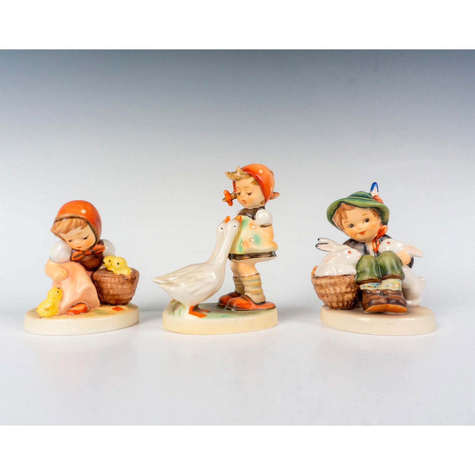 3pc Goebel Hummel Farm Theme Figurines: A collection of 3 delightful Hummel pieces. Chick Girl captures a sweet moment as a young girl tends to a cluster of adorable chicks, Goose Girl charmingly portrays a young girl accompanied by a frien