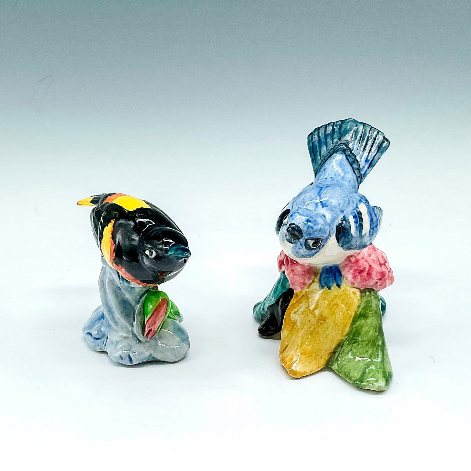 2pc Stangl Pottery Figurines, Cerulean Warbler & Oriole: Colorful Warbler with blue body and darker accents seated on multicolored base 3456 - 3"L x 4.5"W x 4.25"H and Oriole colored in yellow and black, perched on flower base with green leaves 3402 - 2.25"