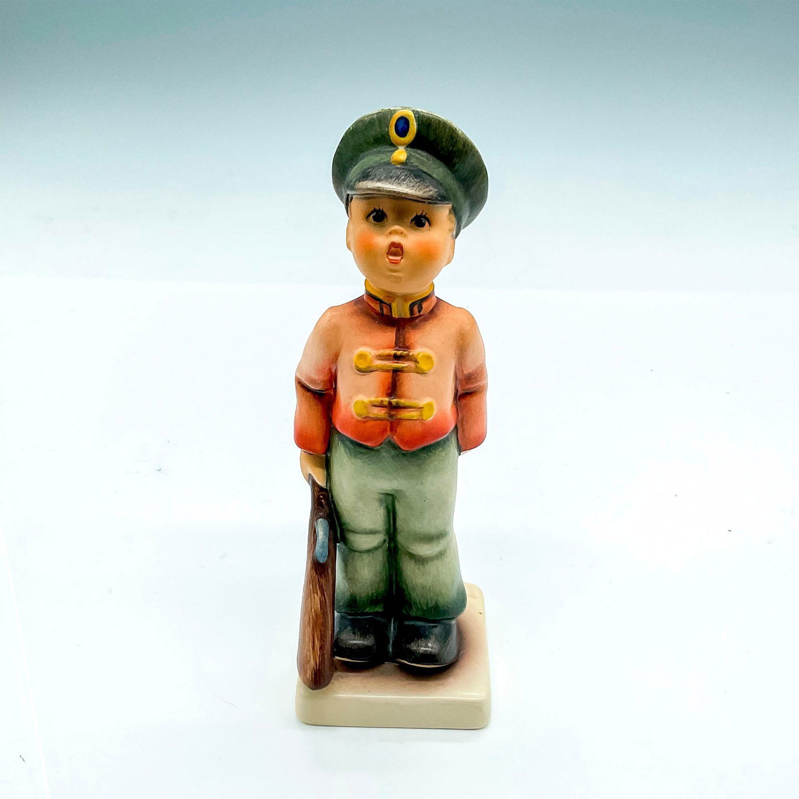 Goebel Hummel Porcelain Figurine, Soldier Boy: Hand painted boy in soldier uniform with rifle. Goebel Germany backstamp. Impress mark 332. Issued: 1991 Dimensions: 2"L x 2"W x 5.5"H Manufacturer: Goebel Hummel Country of Origin: Germany