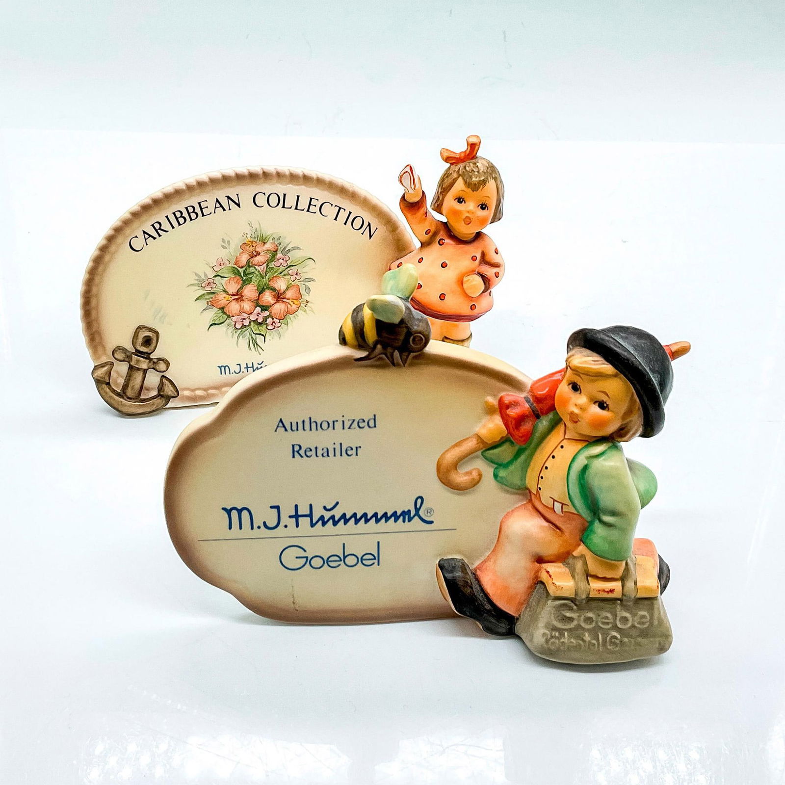 2pc Goebel Hummel Porcelain Dealer Signs: Authorized Dealer hand painted boy with bee and umbrella. Goebel Germany backstamp. Impress mark 900. Caribbean Collection sign with girl in polka dot dress. Goebel Germany backstamp. Impress mark 820