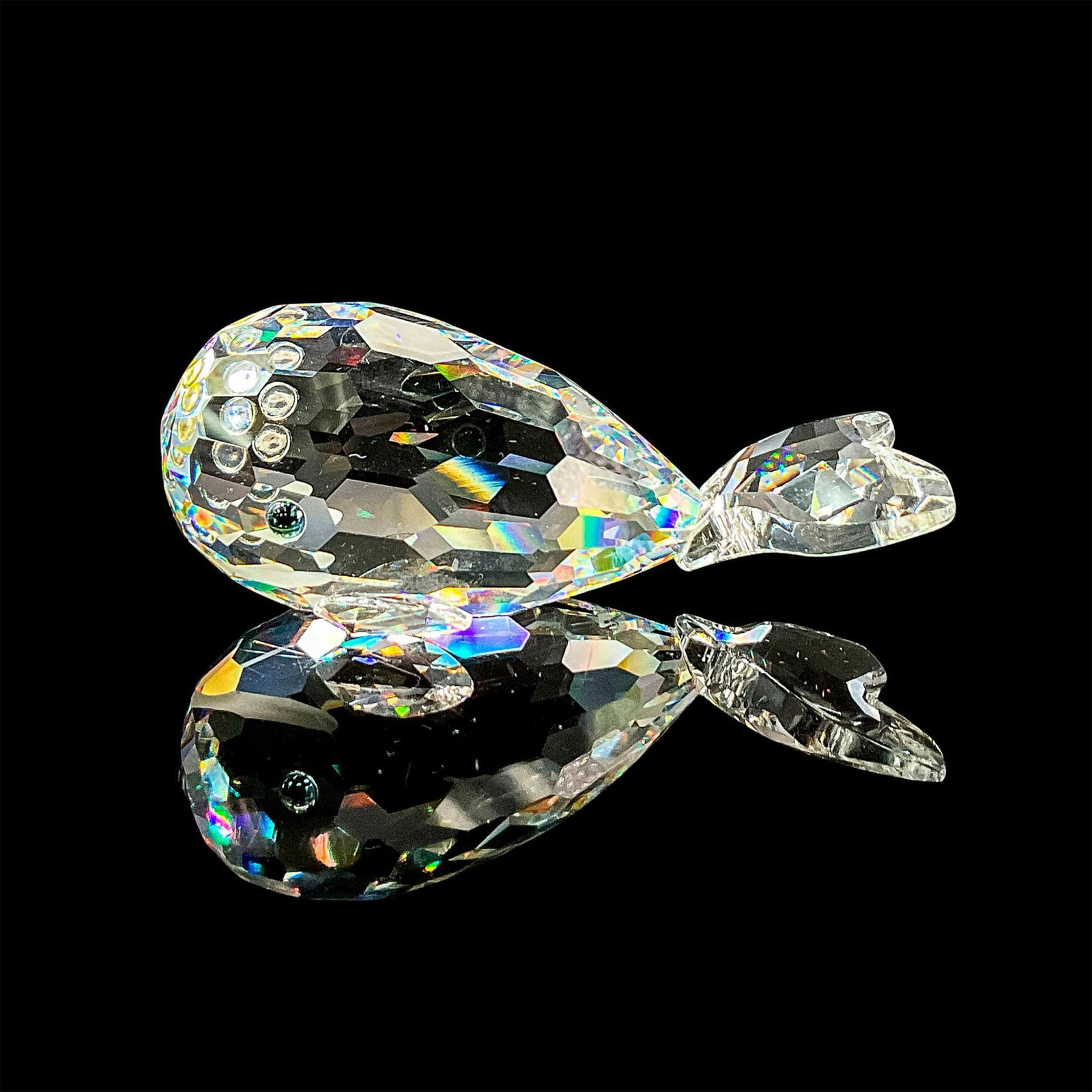 Swarovski Crystal Figurine, Moby Dick: Clear faceted crystal figure of a happy smiling whale with blue/green eyes. Swarovski mark. Dimensions: 3"L x 1.75"W x 1.25"H Manufacturer: Swarovski Country of Origin: Austria