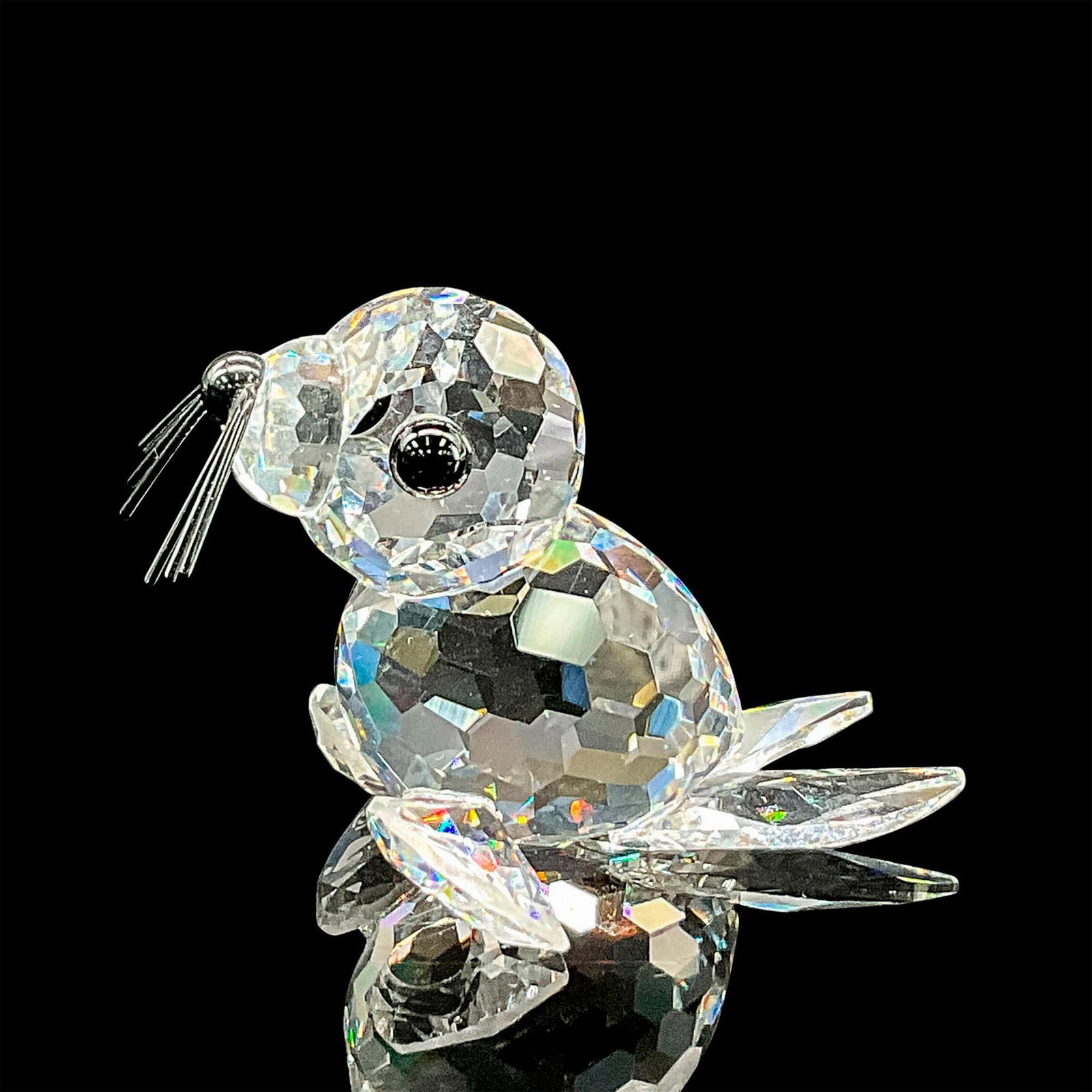Swarovski Crystal Figurine, Seal: Clear faceted crystal figure of a perky seal with black eyes, nose and whiskers. Swarovski etched mark. This item has its original box: 2.5"H x 3.25" dia. Certificate of Authenticity included. Dimensi