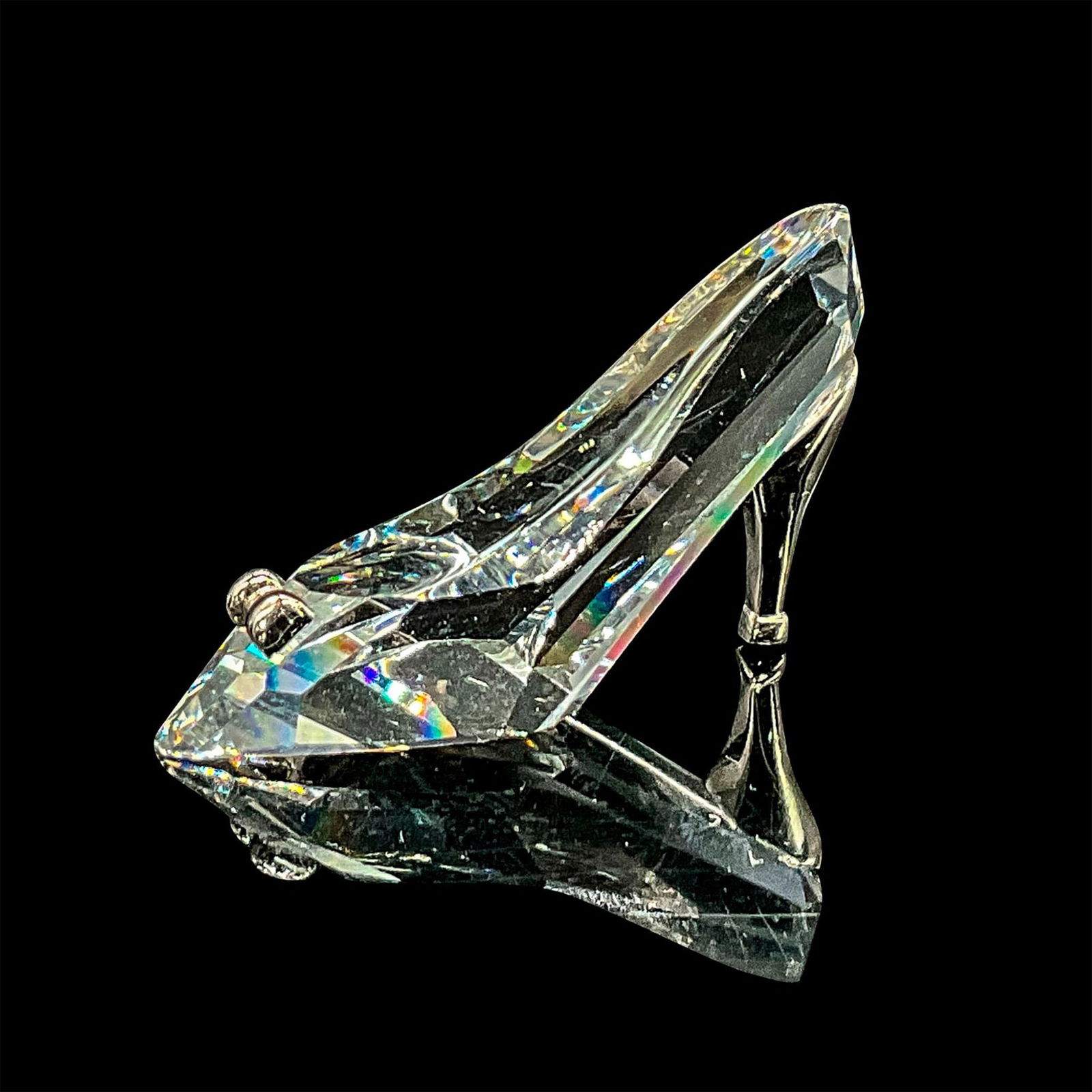 Swarovski Crystal Figurine, High-Heeled Shoe: Clear faceted crystal mini figure of a high-heeled shoe with a rhodium heel and bow. Swarovski mark. 9460 NR 000 151. This item has its original box: 2.25"L x 2.25"W x 1.25"H. Certificate of Authentic