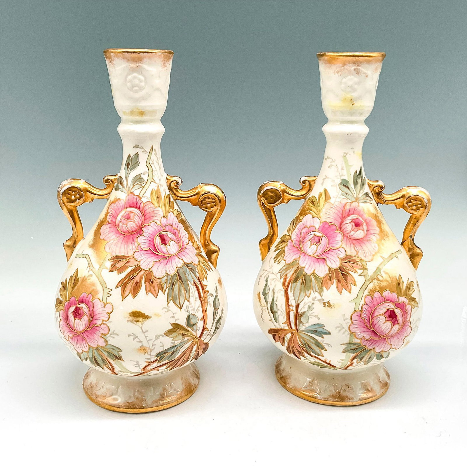 Pair of Royal Bonn Franz Anton Mehlem Vases: Lovely floral detail over porcelain with gilt accents on handle and rims. Royal Bonn backstamp. Impressed 338. Issued: 20th century Dimensions: 9.25"H x 4.5"W Manufacturer: Royal Bonn Country of Origi
