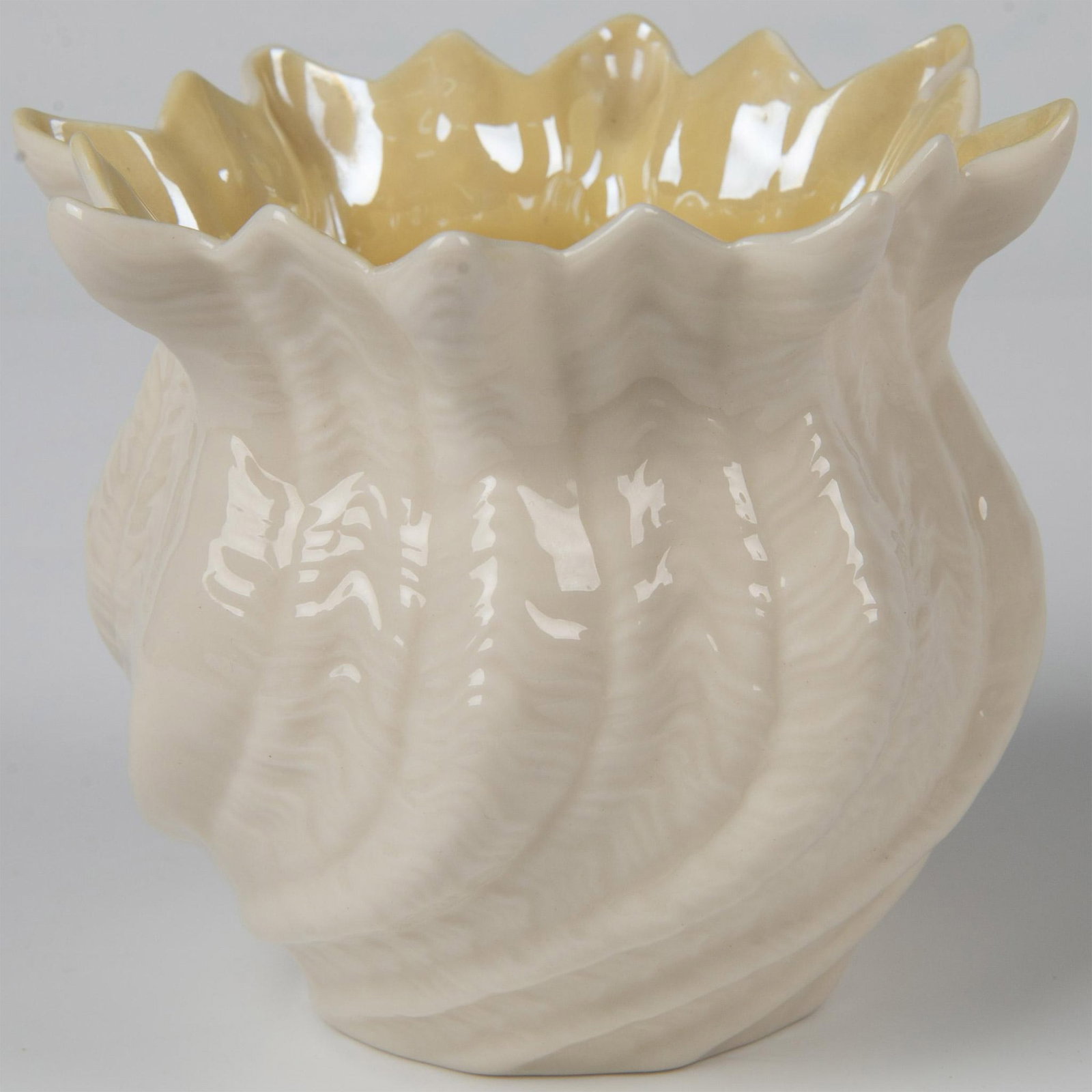 Belleek Pottery Porcelain Cachepot, Limpet Yellow: A porcelain flower pot decorated in the Limpet Yellow pattern with an ivory colored exterior, yellow interior, and a lustre finish. Belleek backstamp. Issued: 1980-1993 Dimensions: 5"W x 4.5"H Manufac