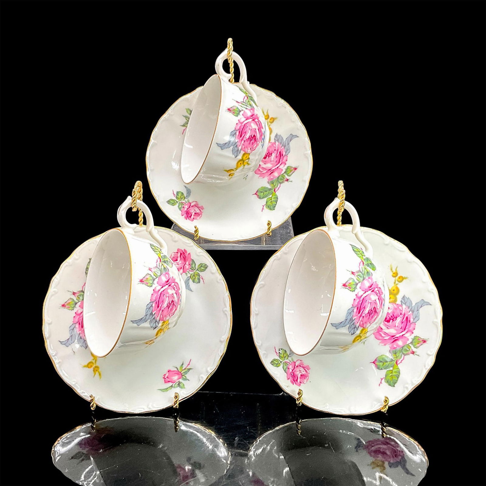 9pc Fine Bohemian China Cups/Saucers/Stands, Flowers: Three white bone china cups and three saucers with colorful floral motif, gold rims. Fine Bohemian China backstamp. Cups 4.75"L x 3.5"W x 2.25"H. Saucers 0.75"H x 5.75" diameter. Includes three stands