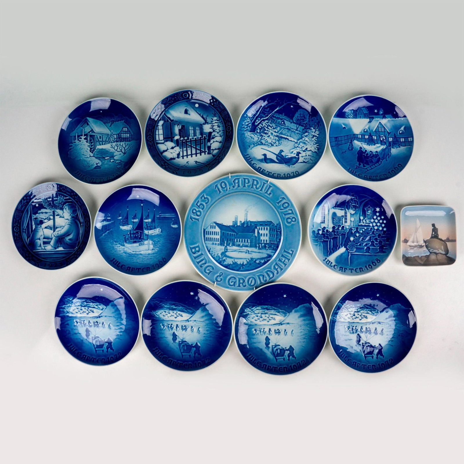 13pc Bing & Grondahl Plate Grouping: Captivating and diverse Bing & Grondahl wall plate collection in stunning blue and white, spanning from 1966 to 1978. The set includes plates from the years 1966, 1968, 1969, 1970, (four plates from) 
