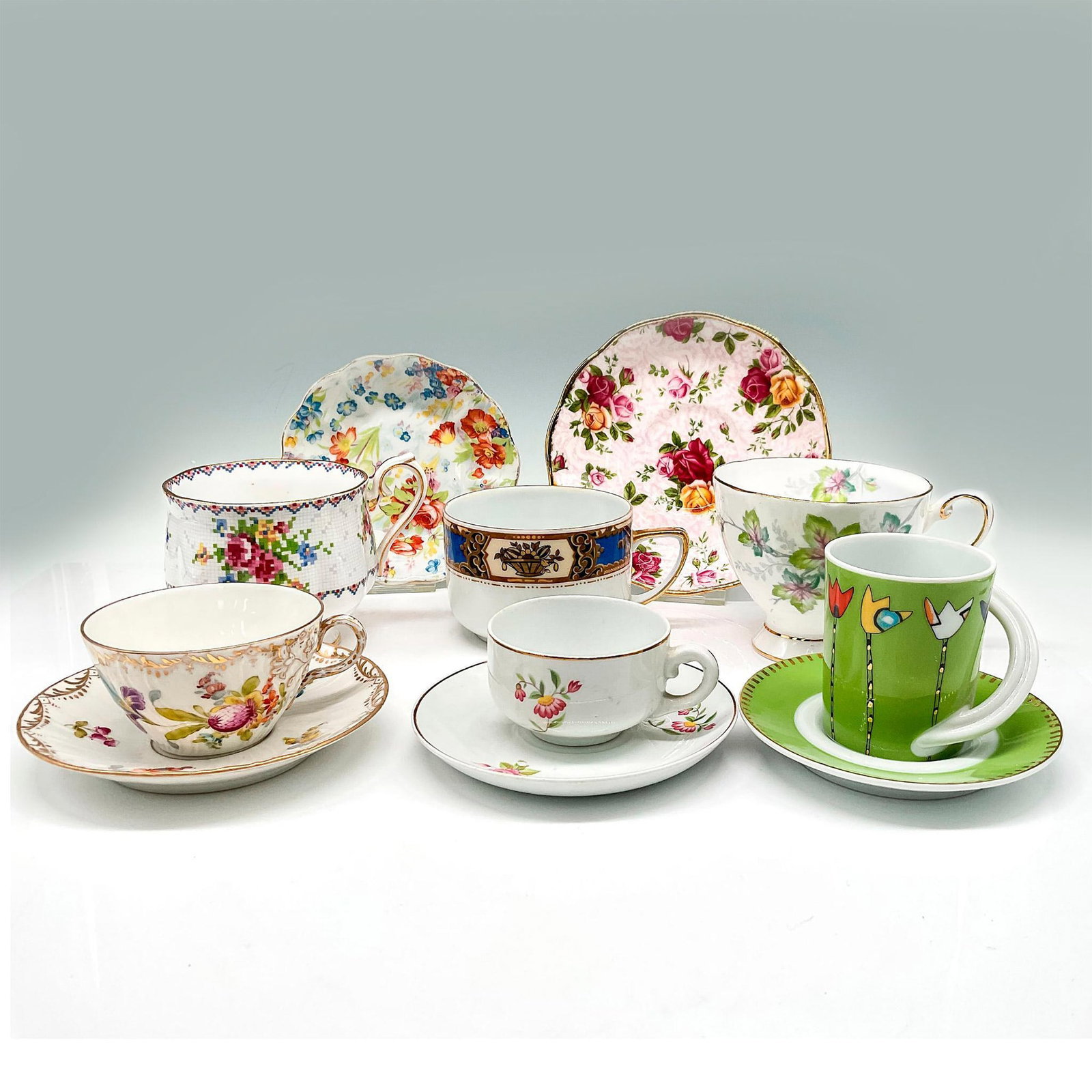 14pc Mixed Lot of Porcelain + Bone China Teacups, Saucers: Variety of floral designs on this mix of 6 cups, 5 saucers and 3 display racks. Rosenthal, Royal Albert, Tuscan and others. Backstamps. Largest piece: 1"H x 5.5" diameter. Issued: 20th century