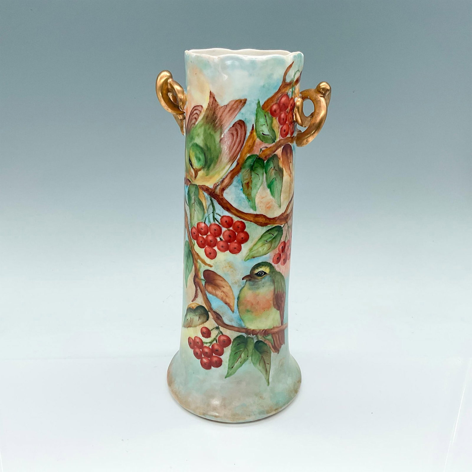 Antique Bavarian Porcelain Vase, Hand Painted Birds: Elegant vase featuring twisted gold double handles, adorned with hand-decorated scenes of three colorful birds perched on branches, accented by small red berries. Bavaria stamped to base. Issued: 20th