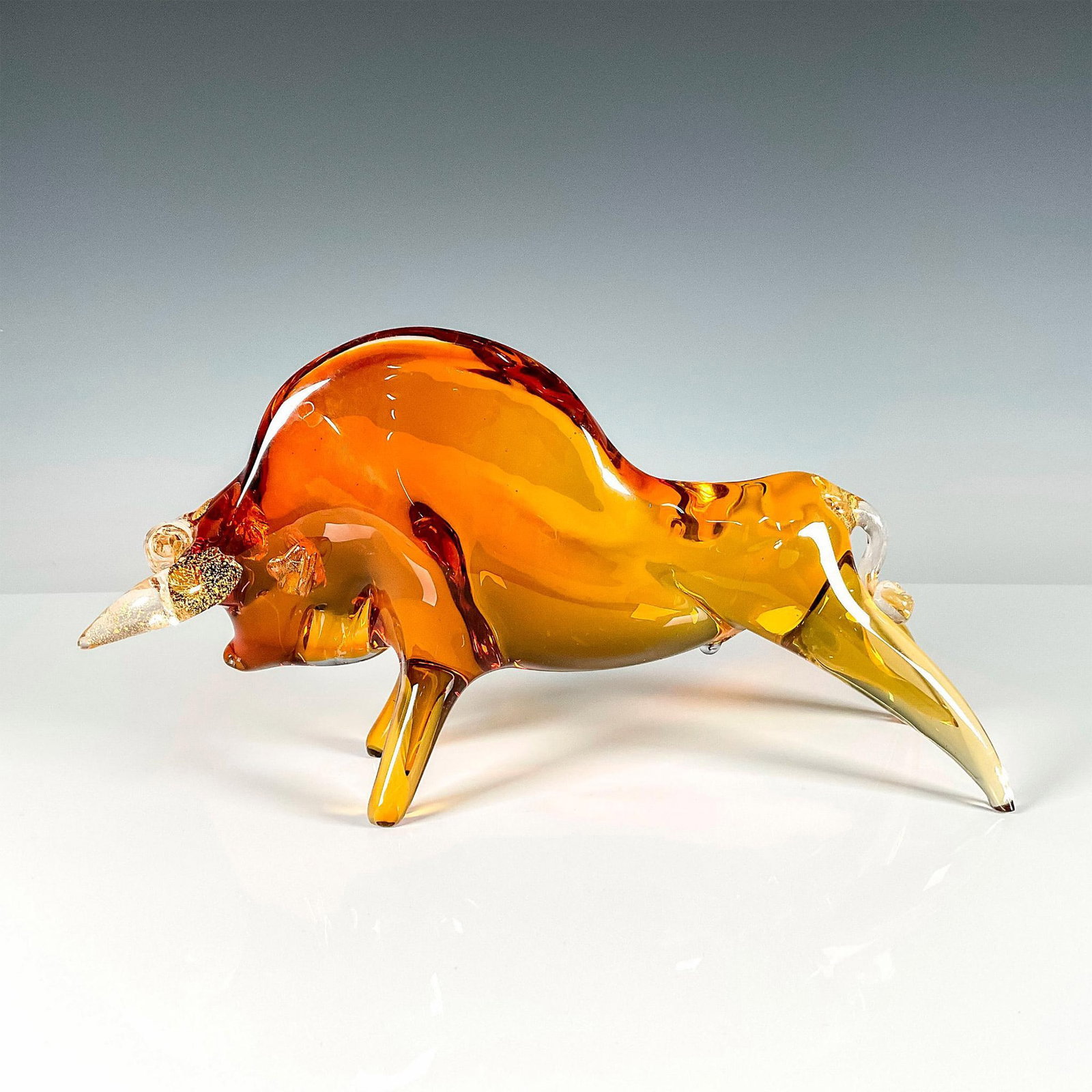 Salviati Murano Art Glass Bull Sculpture: Amber colored figure showing a fierce fighting bull. Further gold details to interior of the horns, ears, and tail. Dimensions: 4"W x 11.5"L x 6"H Manufacturer: Salviati & C Country of Origin: Italy