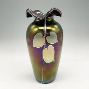 Stuart Abelman Art Glass Iridescent Black Glass Vase, Signed: Stunning furled edge mouth to cylindrical body. Iridescent colors offset leaf and vine design. Signed by artist. Abelman etched 1987. VLB333-246. Artist: Stuart Abelman Issued: 1987 Dimensions: 8.25"H