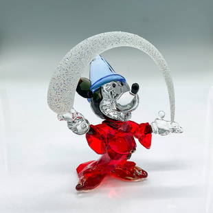 Swarovski Silver Crystal Figurine, Sorcerer Mickey: Faceted and smooth crystal figure of Mickey Mouse dressed as the character Sorcerer's Apprentice from the Disney film Fantasia, holding a magical wave. He wears a red dress robe, blue hat, topaz shoes