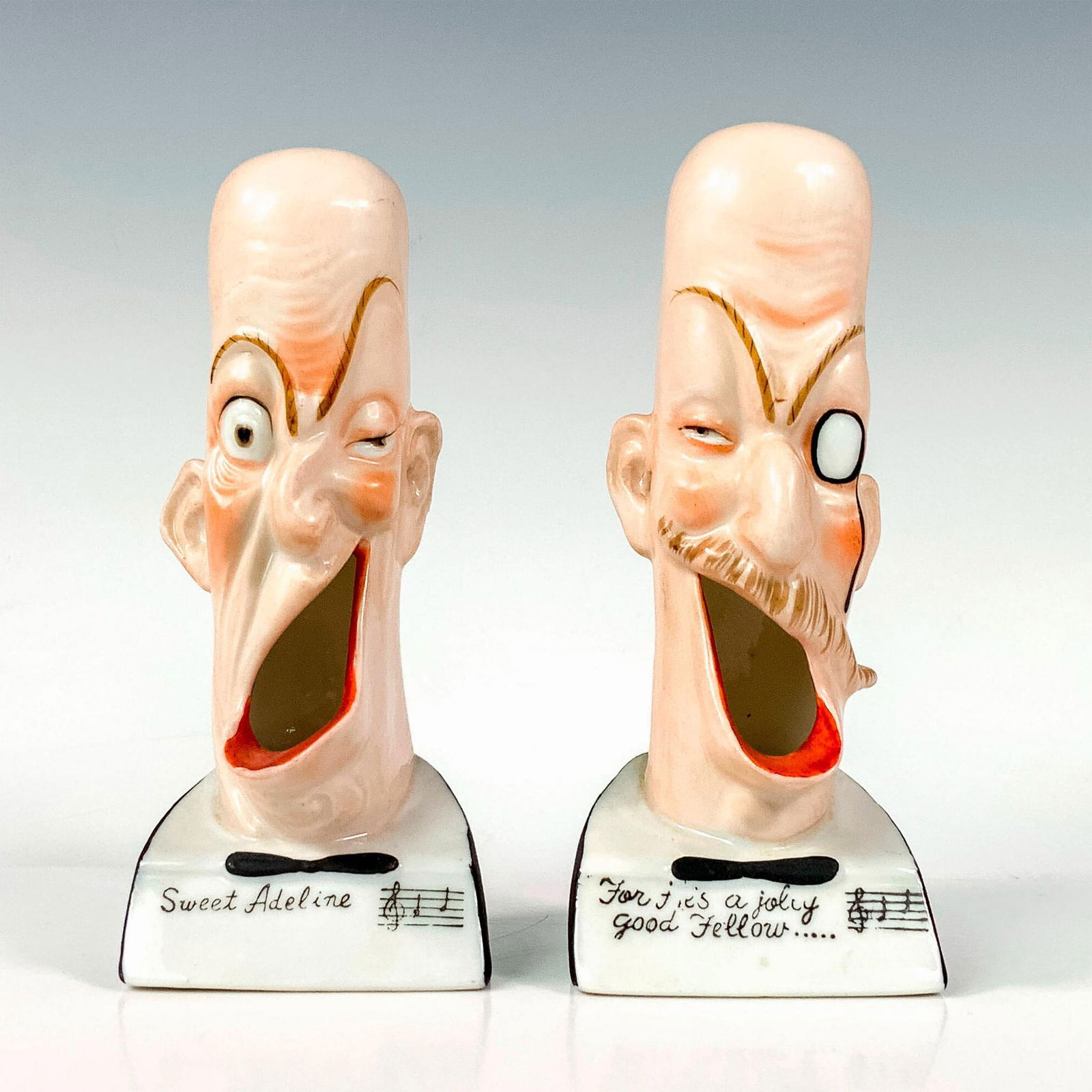 Pair of Schafer and Vater Ashtrays: Two figures depicting opera singers. One marked Sweet Adeline and the other For He's a Jolly Good Fellow written on the front of the bases. Issued: c. 1920 Dimensions: 2.25"L x 2"W x 5.25"H Manufactur