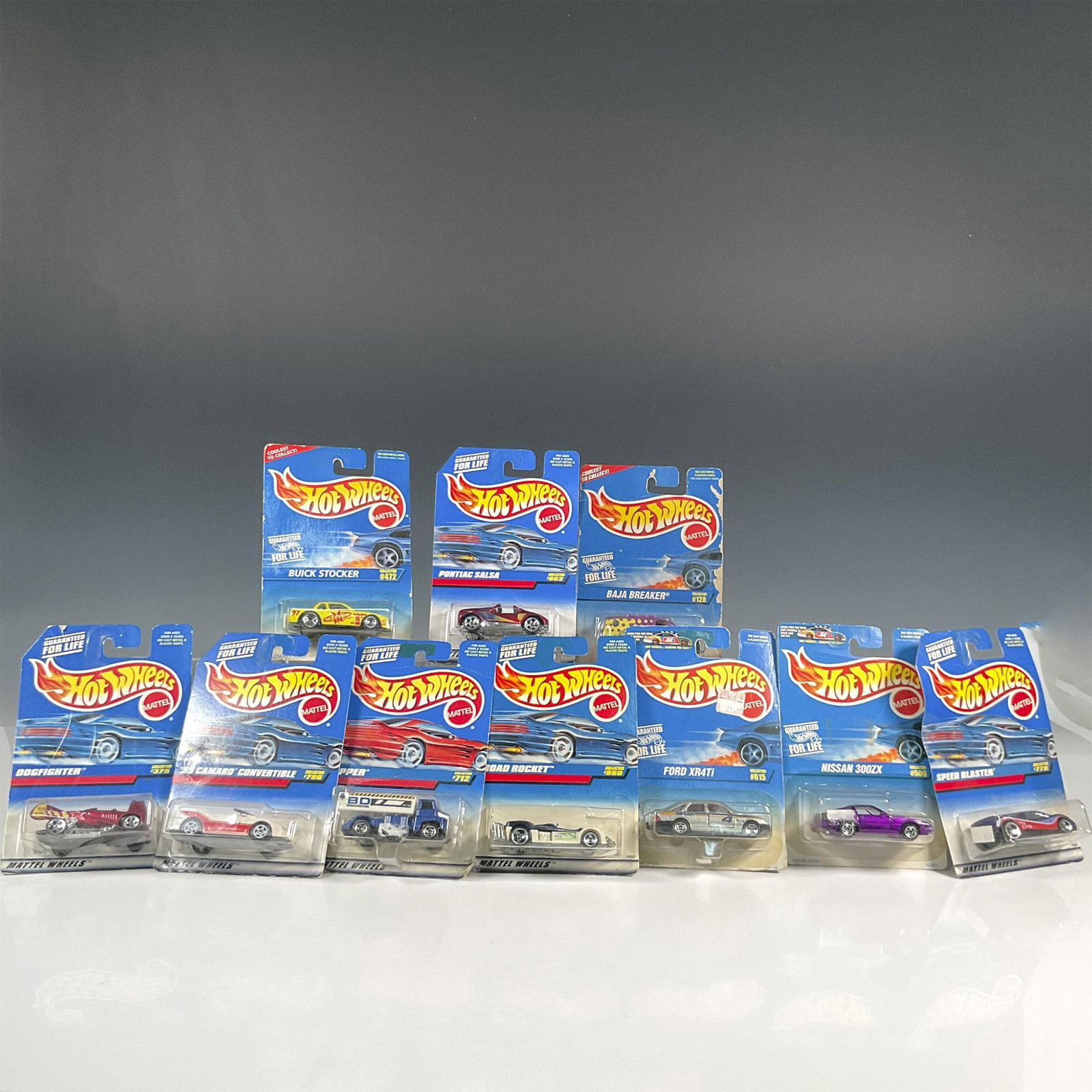 10pc Hot Wheels Collectors Toy Cars: A set of 10 Hot Wheels car that includes the Ford XR4Ti (Collector #615), the Road Rocket (Custom Collection #860), '95 Camaro Convertible (Collector #796), the Tipper (Collector #712), the Nissan 300