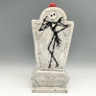 Disney Porcelain Jack Skellington Cookie Jar: Tombstone designed off white canister with Jack prominently displayed on front with pumpkin pull on lid. Treasure Craft and Disney backstamp. Issued: 20th century Dimensions: 7"L x 6"W x 16.5"H Manufa