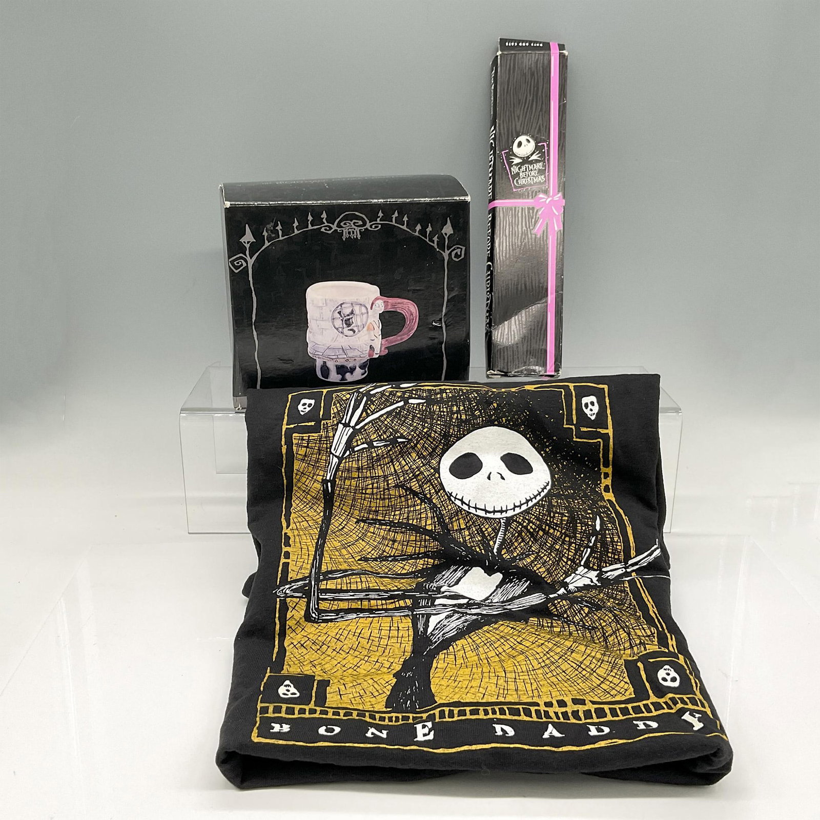 3pc Tim Burton's Nightmare Before Christmas Collectibles: Includes items created from characters of the movie: Cats and Bats plastic wristwatch (2.25"L x 9.5"W x 1"H), Bone Daddy Black T-shirt (size M) and porcelain Sally mug. NECA backstamp. This item is th