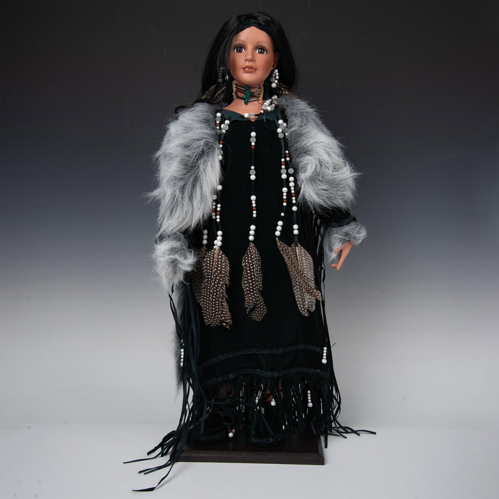 Timeless Indian Collections Porcelain Doll, Indian Princess: New in original packaging. Intricately designed with black hair adorned with beads and feathers. Dressed in emerald, green tasseled microsuede dress with matching moccasins. Matching faux fur jacket.