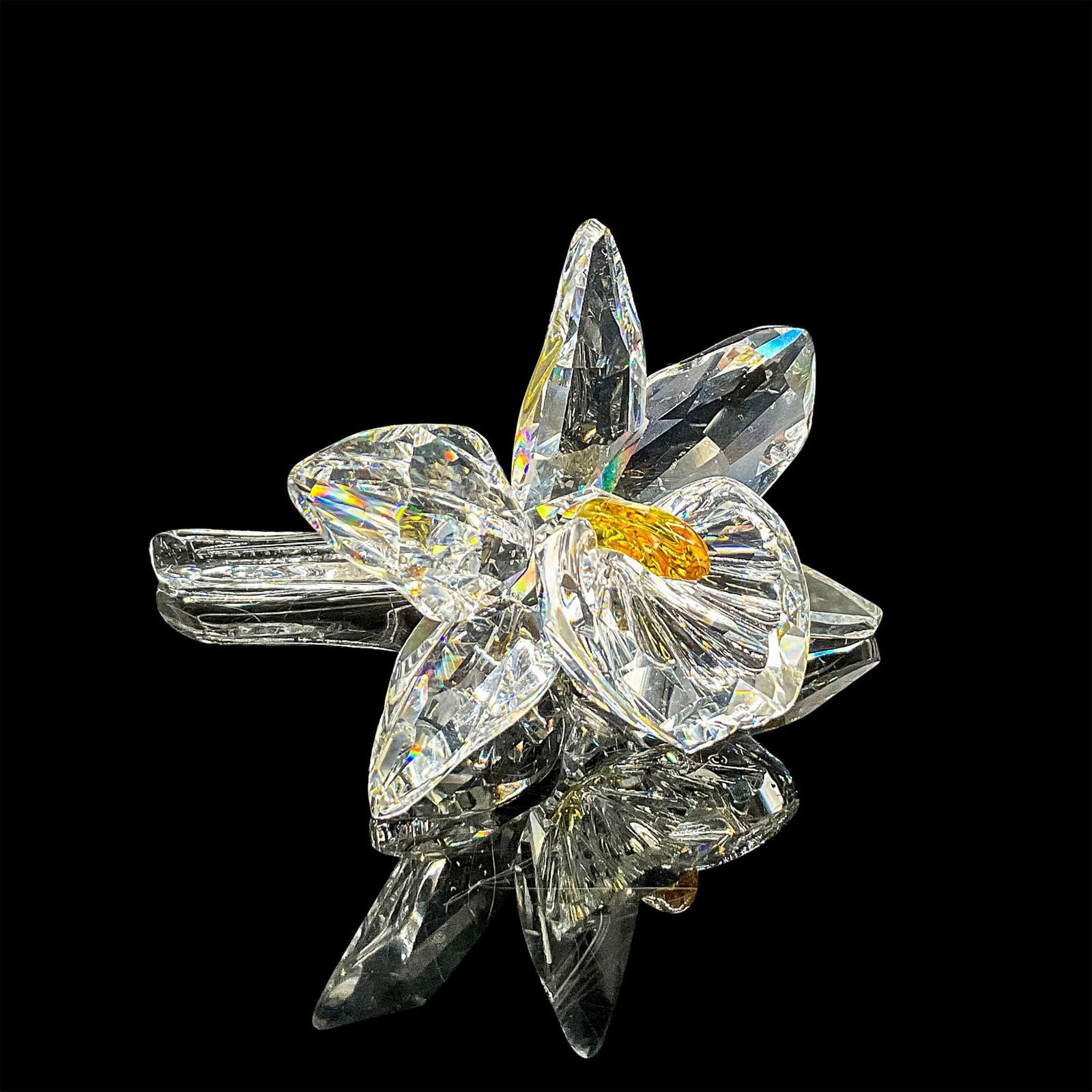 Swarovski Silver Crystal Figurine, Orchid Yellow Pistil: Clear faceted crystal figure of an orchid with a deep yellow pistil. Swarovski mark. Item number 7478NR000002. Part of the Exquisite Accents collection. This item has its original box: 5"H x 6"dia. Ce