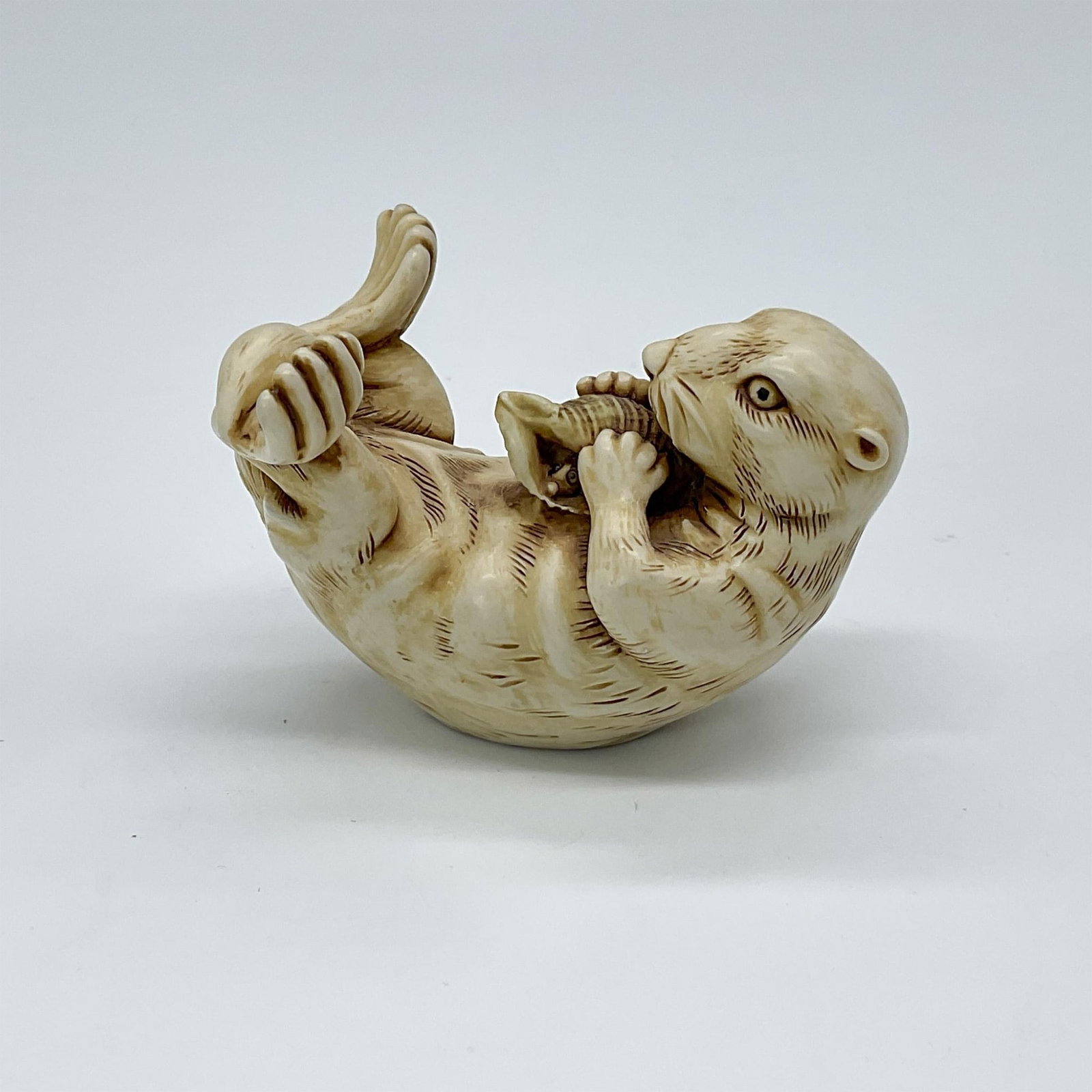 Harmony Kingdom Figurine, Tarka: Featuring sea otter with whiskers laying on its back holding a shell. Harmony Kingdom sticker on base. #tarka #figurine #harmony #otter #whiskers Artist: Peter Calvesbert Issued: 1999 Dimensions: 2.25