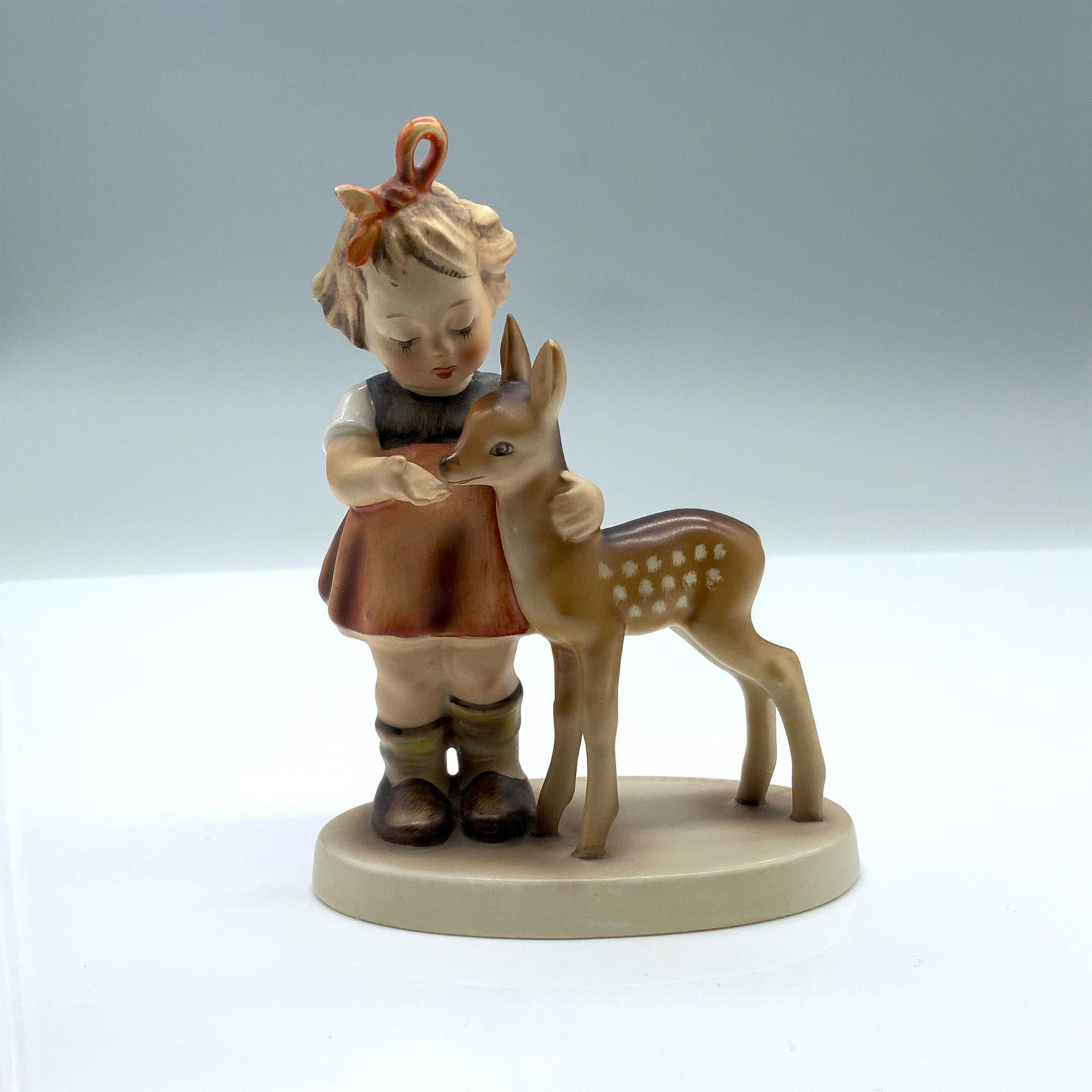 Friends 136/1 - Goebel Hummel Figurine: Hand-painted figurine depicting a young girl and a deer. Goebel backstamp on the bottom. Artist: Reinhold Unger Issued: 1947 Dimensions: 4"L x 2.25"W x 5.25"H Manufacturer: Goebel Hummel Country of O