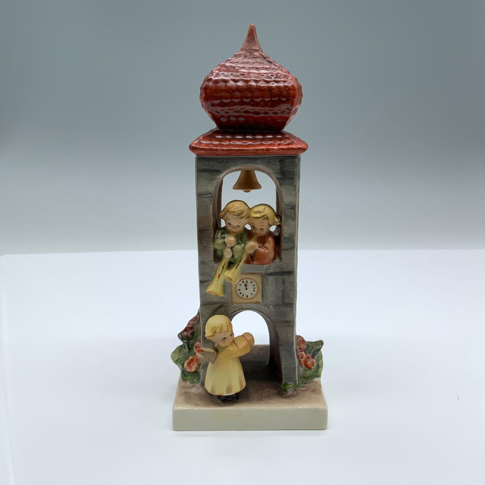Whitsuntide 163 - Goebel Hummel Figurine: Hand painted figure of a tower with angels. Goebel backstamp on the bottom. Dimensions: 3"L x 2.75"W x 7"H Manufacturer: Goebel Hummel Country of Origin: Germany