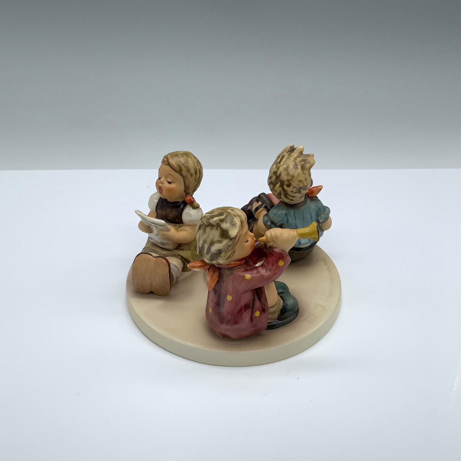 Goebel Hummel Little Band Candle Holder: Hand-painted porcelain candle holder with three kids making music. Goebel backstamp on the bottom. Dimensions: 5"dia. x 3.25"H Manufacturer: Goebel Hummel Country of Origin: Germany