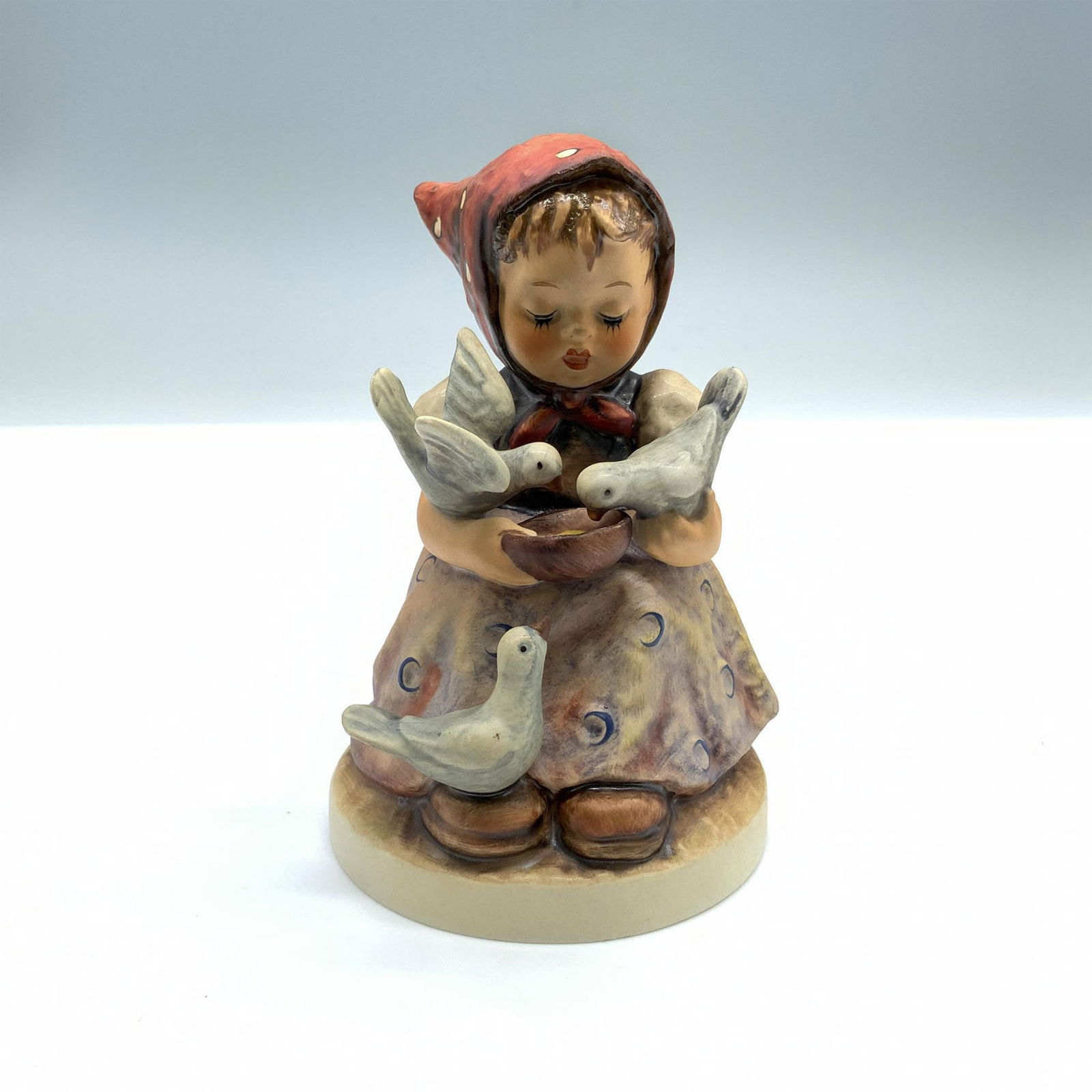 Goebel Hummel Porcelain Figurine, Cinderella 337: Hand-painted figurine depicting a girl feeding birds. Goebel backstamp on the bottom. Artist: Arthur Moeller Issued: 1972 Dimensions: 4.75"H Manufacturer: Goebel Hummel Country of Origin: Germany