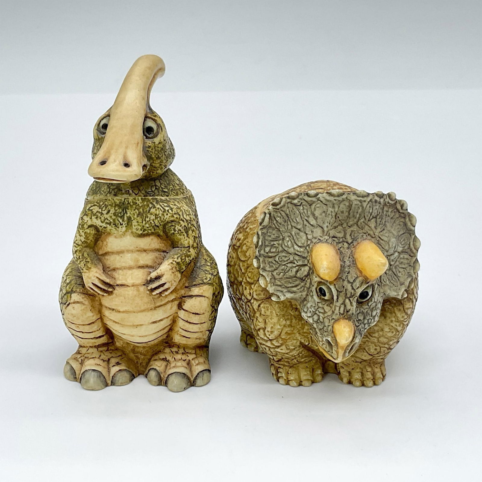 2pc Pot Belly Treasure Boxes, Horn Face & Duck Head: Two fabulous decorative boxes, both crafted from crushed marble. Both boxes depict adorable representations of dinosaurs. The slightly larger piece measures 2.5"L x 2"W x 2.75"H. Pot Belly backstamp.