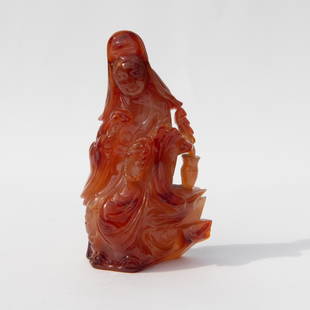 Antique Chinese CarnelianAgate Guanyin Figurine: Beautifully carved carnelian agate stone of the Bodhisattva seated on a bench beside a vase of feathers. Dimensions: 2.25"L x 1.25"W x 4"H Country of Origin: China