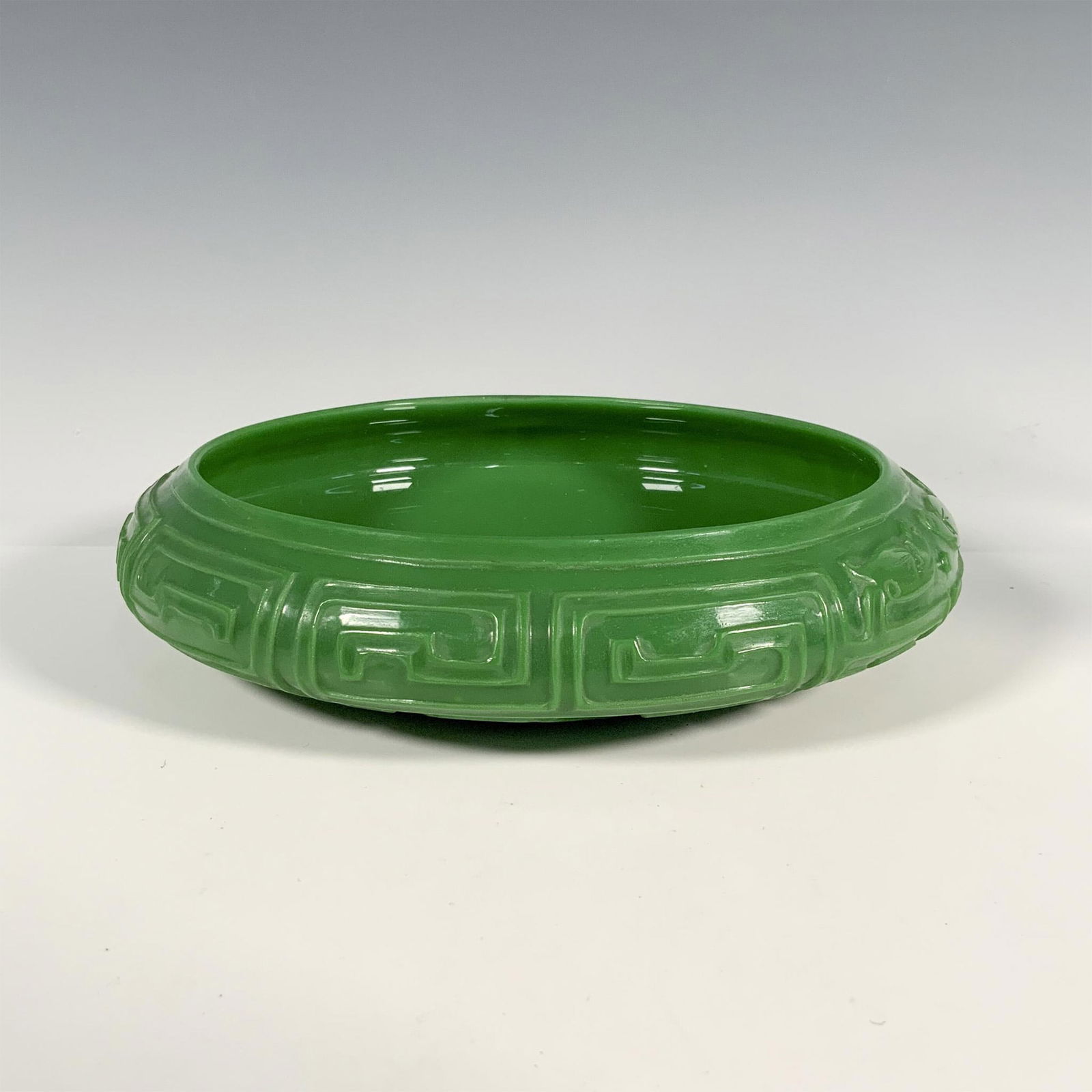 19th Century Chinese Imperial Peking Glass Bowl: A lustrous emerald green Chinese Peking glass centerpiece bowl, exterior perfectly carved motifs. Dimensions: 2.5"H x 8.5" dia. Country of Origin: China