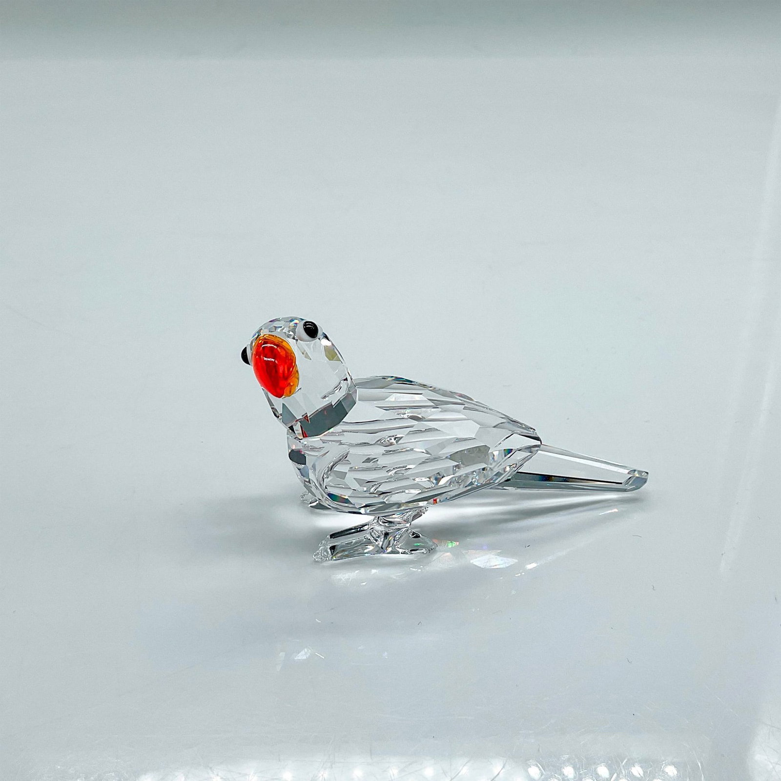 Swarovski Silver Crystal Figurine, Parrot: Sparkling clear faceted crystal figure of a parrot with orange beak. Part of the Feathered Beauties collection. Swarovski etched backstamp. This item has its original box 4.5"H x 3.25"dia. Issued: 200