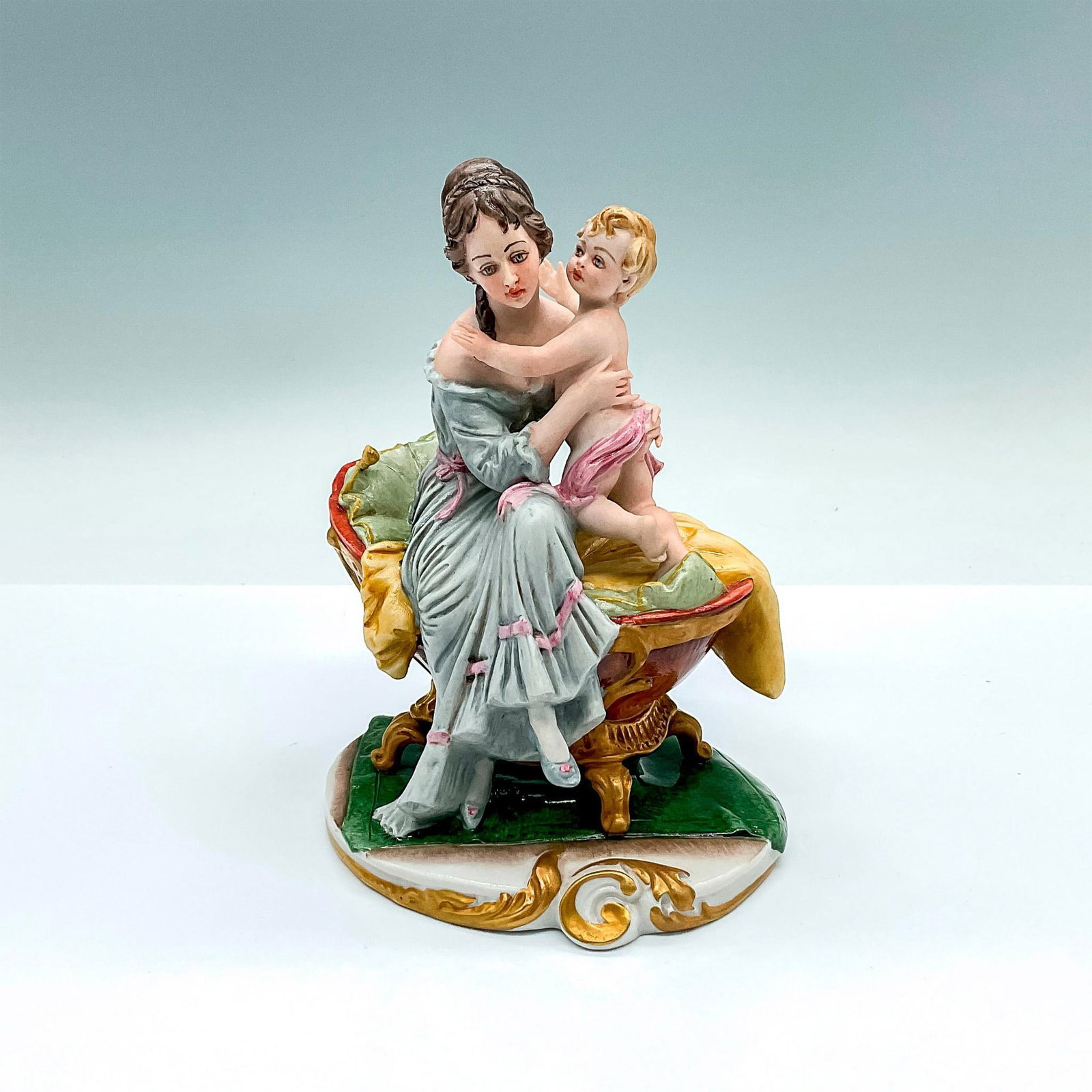 Capodimonte Bellaire Porcelain Figurine, Mother And Child: Hand painted polychrome figure with gilded highlights. Depicts a mother with child in her arms. Signed Bellaire on the side. Capodimonte mark in circle on the underside. Artist: D. Bellaire Issued: c.