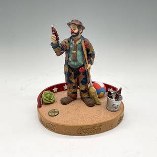 Coke Brand Ceramic Figurine, Emmett Kelly Pause for a Coke: First limited-edition figurine of Kelly standing with a broom in circus atmosphere looking at a Coke. Number 230. Coca-Cola impressed mark on base and backstamp. This item has its original box: 7"L x