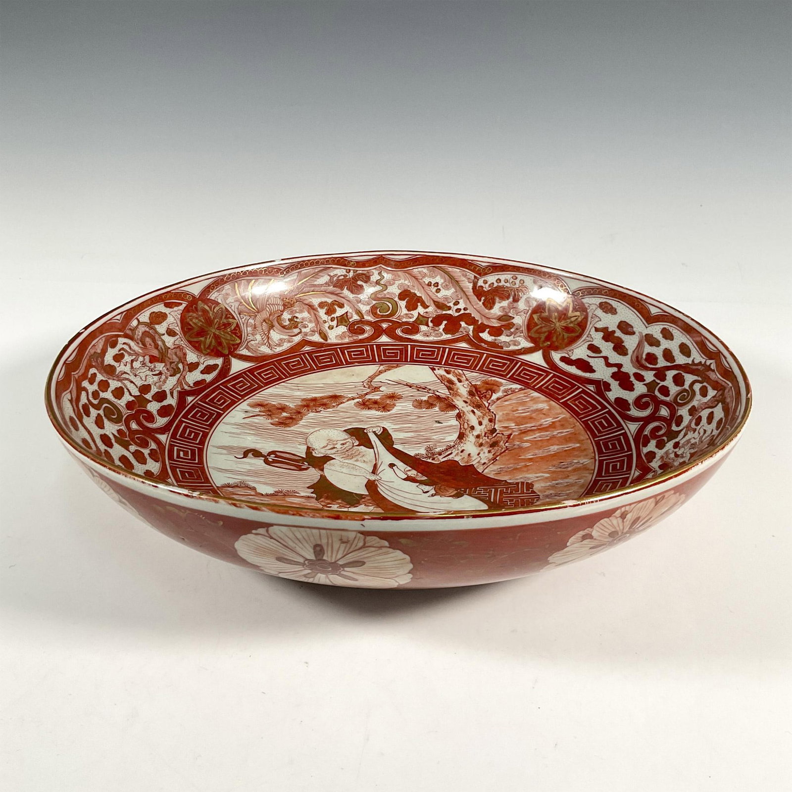 Japanese Kutani Porcelain Charger: Antique porcelain Kutani charger decorated on its exterior with flowers and aesthetic patterns and on its interior with a scene of a Louhan with dragon. The borders with intricate floral and cloud pat