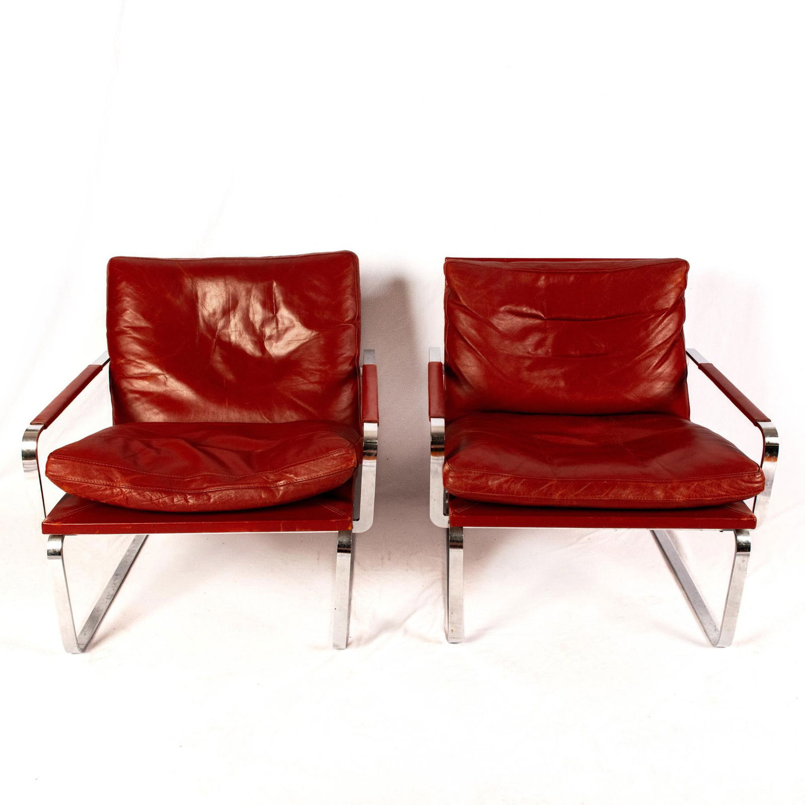 Pair of Jorgen Lund and Ole Larsen for Bo-Ex Lounge Chairs: A set of two red leather chairs in a steel chromed frame. Artist: Jorgen Lund and Ole Larsen Issued: 1960s Dimensions: 29"L x 28"W x 29"H Manufacturer: Bo-Ex Country of Origin: Denmark