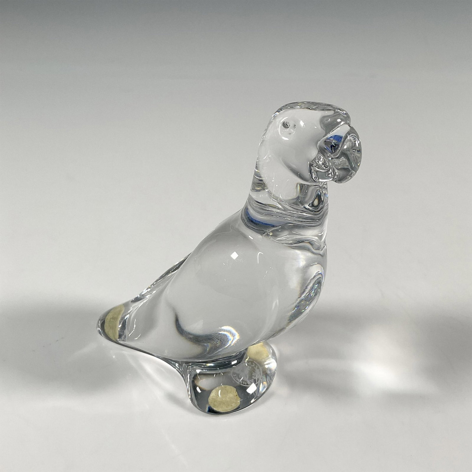 Baccarat Crystal Figurine, Parrot: A French clear crystal design, modeled as a parrot figurine perched. Baccarat backstamp. Dimensions: 2"L x 3.75"W x 4"H Manufacturer: Baccarat Country of Origin: France