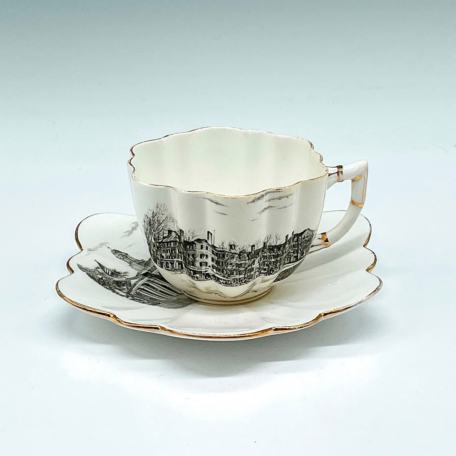 2pc The Foley Bone China Teacup and Saucer, Lenox, Mass.: Graphic black and white design of The Curtis Hotel and Town Hall with gilt edges on rim, handle and base. Set includes teacup 2"H x 3"dia. and saucer 0.75"H x 5"dia. Foley backstamp. Issued: 20th cent