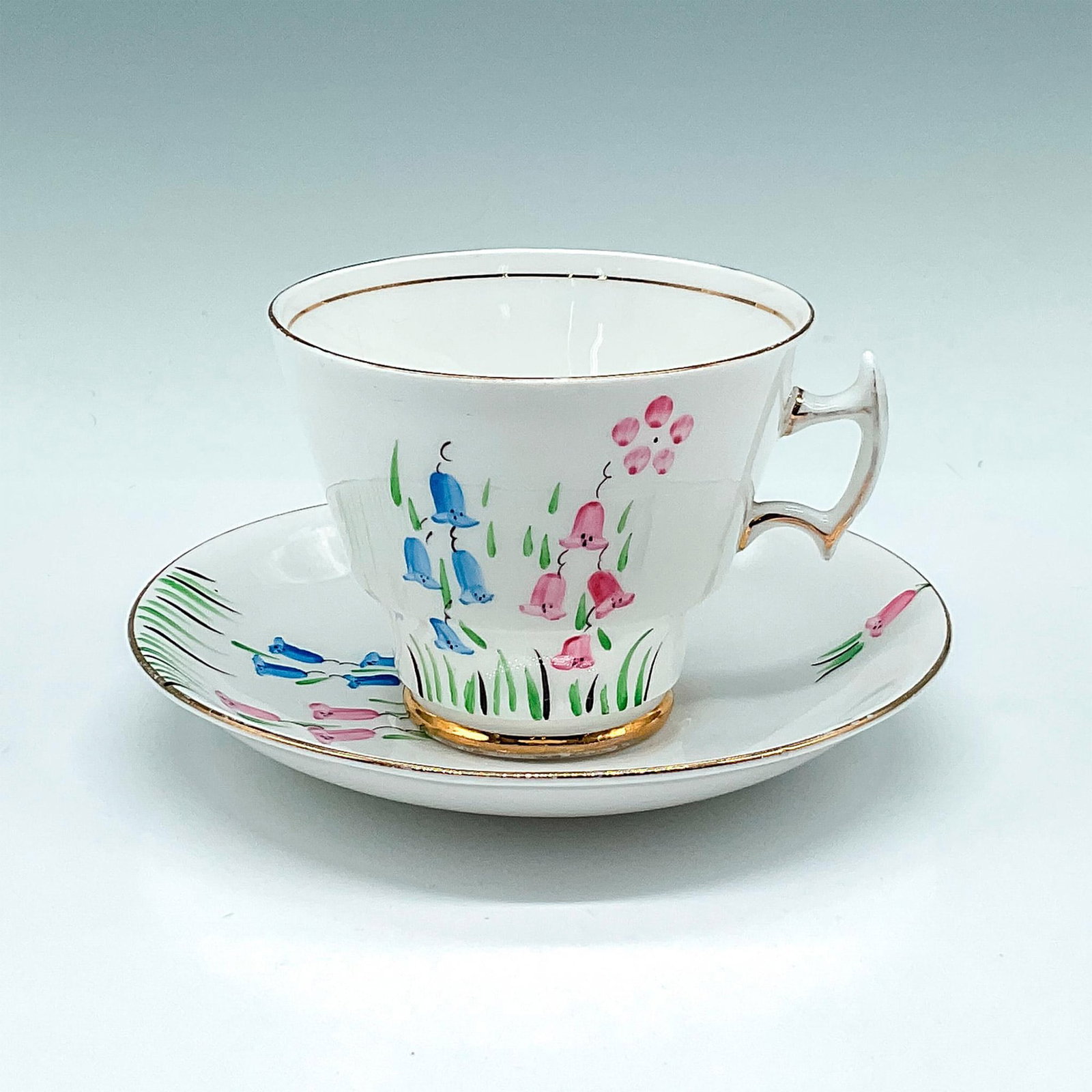 2pc TF&S Phoenix Ware Teacup and Saucer, English Art Deco: Delicate bone china with pink and blue floral design, gilt accents on rim, base and handle. Set includes teacup 3"H x 3.5"dia. and saucer 1"H x 5.5"dia. T.F.&S Ltd. backstamp. Issued: 20th century Man