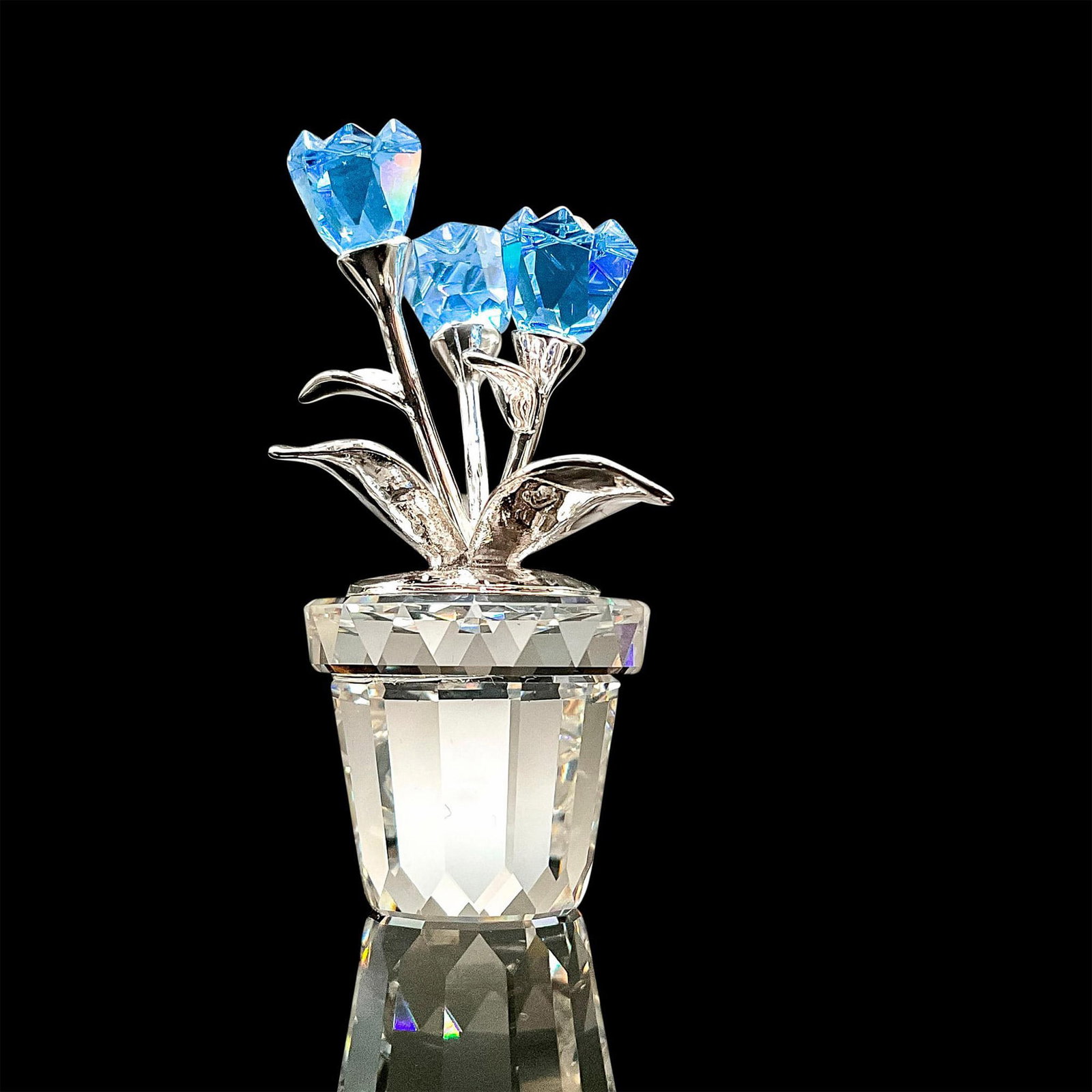 Swarovski Silver Crystal Figurine, Forget-Me-Not: A sparkling faceted crystal figurine modeled as a blue potted flower with silver metal stems. Swarovski acid mark to base. Original box included. Box dimensions: 2.75"L x 2.75"W x 1"H. Dimensions: 1"L