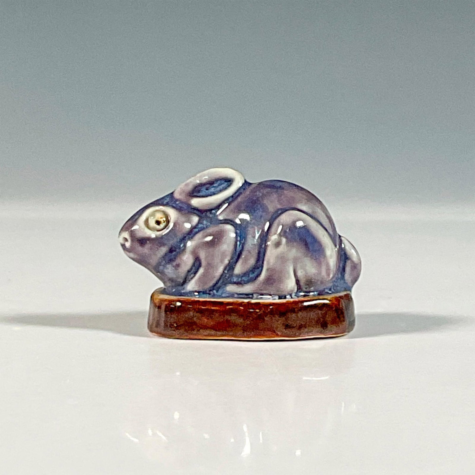 Royal Doulton Mark V Marshall Stoneware Rabbit Paperweight: A rare lilac glazed figure of a rabbit with beady eyes. Royal Doulton backstamp. Artist initials. Artist: Mark V. Marshall Issued: c. 1902 Dimensions: 2.5"L x 1.5"W x 1.25"H Manufacturer: Royal Doulto