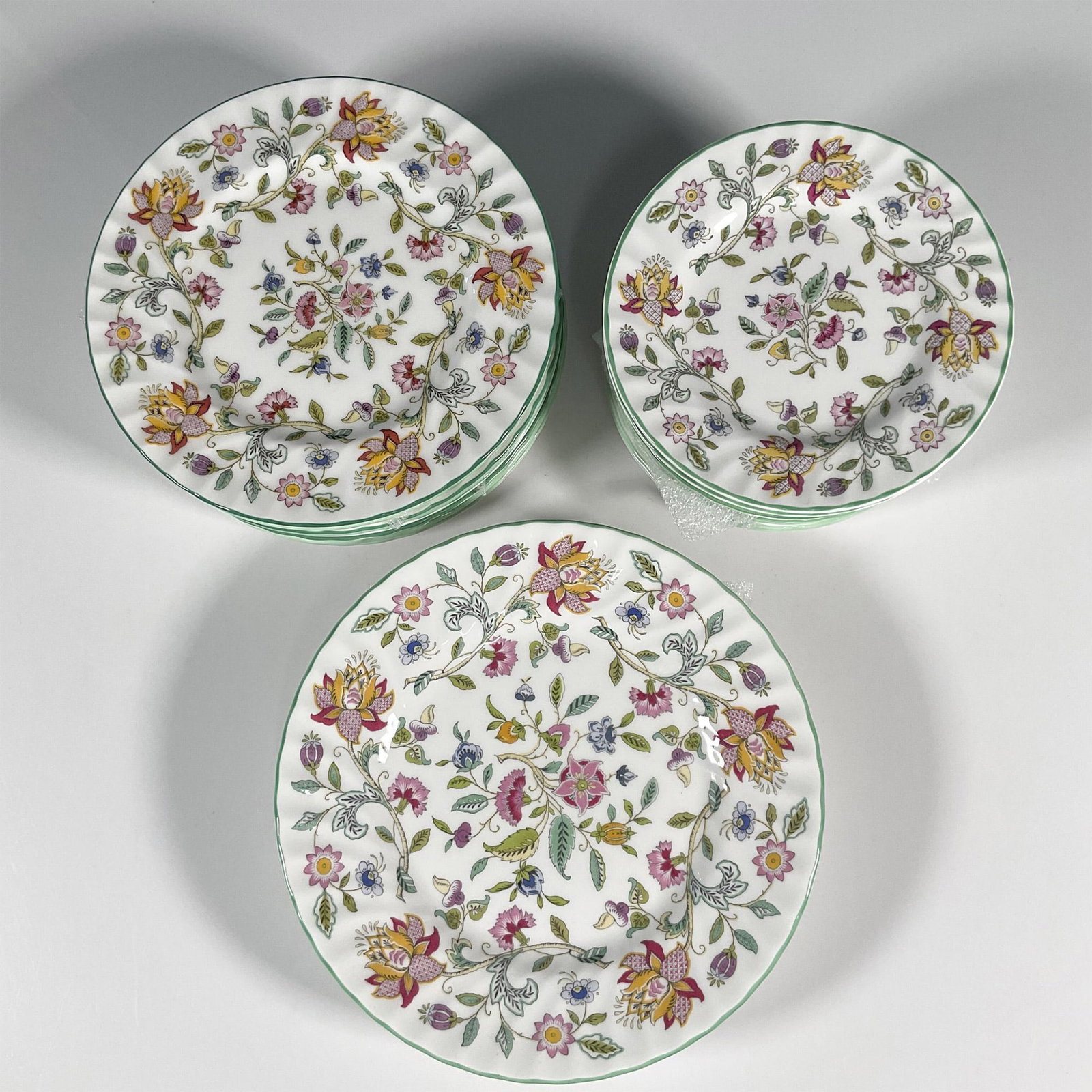 21pc Minton Bone China Assorted Plates, Haddon Hall: A set of assorted plates comprising of 4 Luncheon Plates, 8 Salad Plates and 9 Bread and Butter Plates. All painted with green borders and beautiful springtime flower design. Minton backstamp. Luncheo