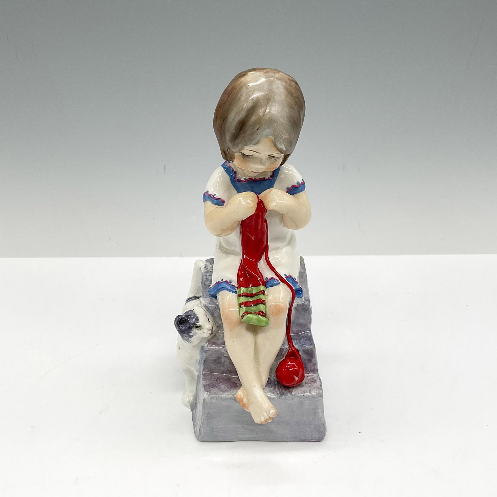 Royal Worcester Porcelain Figurine, Saturdays Child: Hand painted figural with her cat in soft white, blue, red and green. Royal Worcester backstamp. Issued: 20th century Dimensions: 2.25"L x 3"W x 5.5"H Manufacturer: Royal Worcester Country of Origin: 